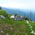 Swiss tents pitched along the hillside at Camp George Everest, Mussoorie