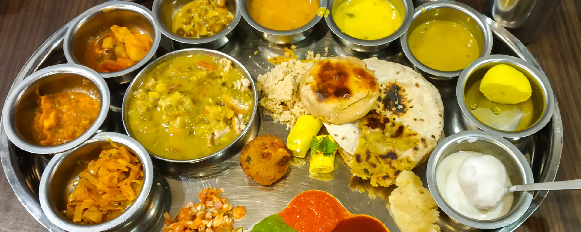 Traditional Pahadi food spread on the Pahadi House deck under warm lighting