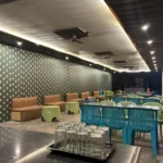 Indoor dining hall at Himalayan Ganga Retreat, long tables laid out for a large group, Rishikesh