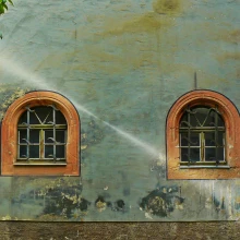 Traditional pahadi stone and mud wall with a window overlooking green Himalayan mountains — eco-conscious living