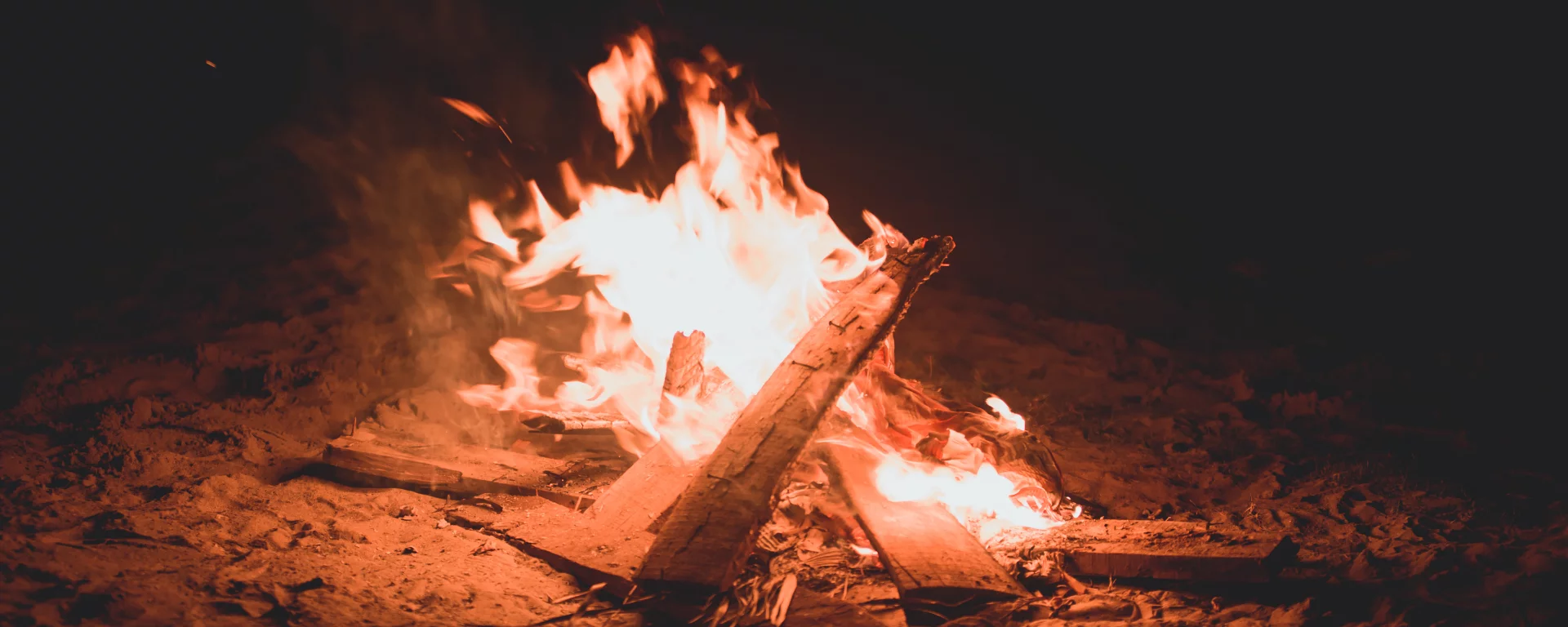 Pahadi House deck illuminated at night with warm firelight