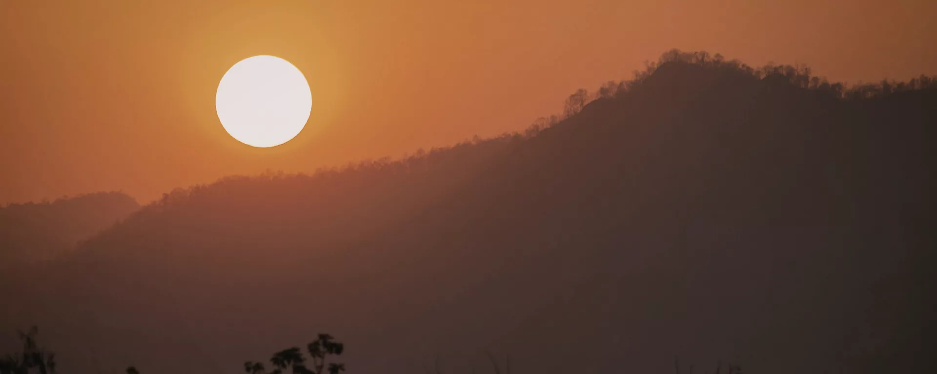 Warm glow of sunrise on distant snow peaks