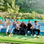 Friends relaxing on the poolside deck at Himalayan Ganga Retreat, Rishikesh