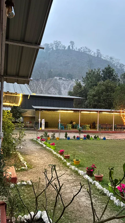 Garden lawn and dining area at dusk, Himalayan Ganga Retreat riverside camp, Rishikesh