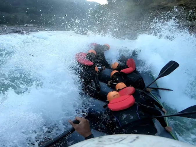 Helmet-cam view of a Rishikesh rafting team punching through a Grade III whitewater rapid on the Ganga