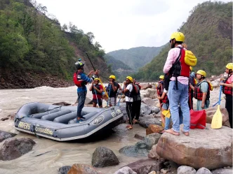 Rishikesh rafting team gathered with a raft on the rocky Ganga riverbank before a Shivpuri to NIM Beach run