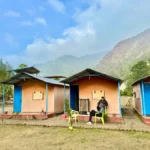 Riverside cottages with Himalayan hills behind at Himalayan Ganga Retreat, Rishikesh