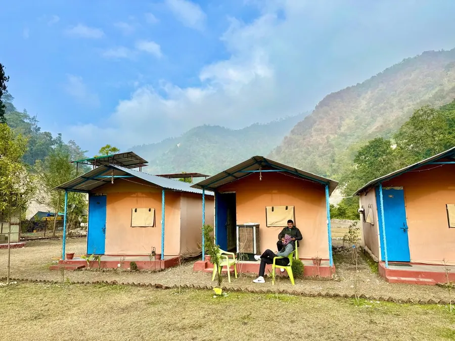Riverside cottages with Himalayan hills behind at Himalayan Ganga Retreat, Rishikesh