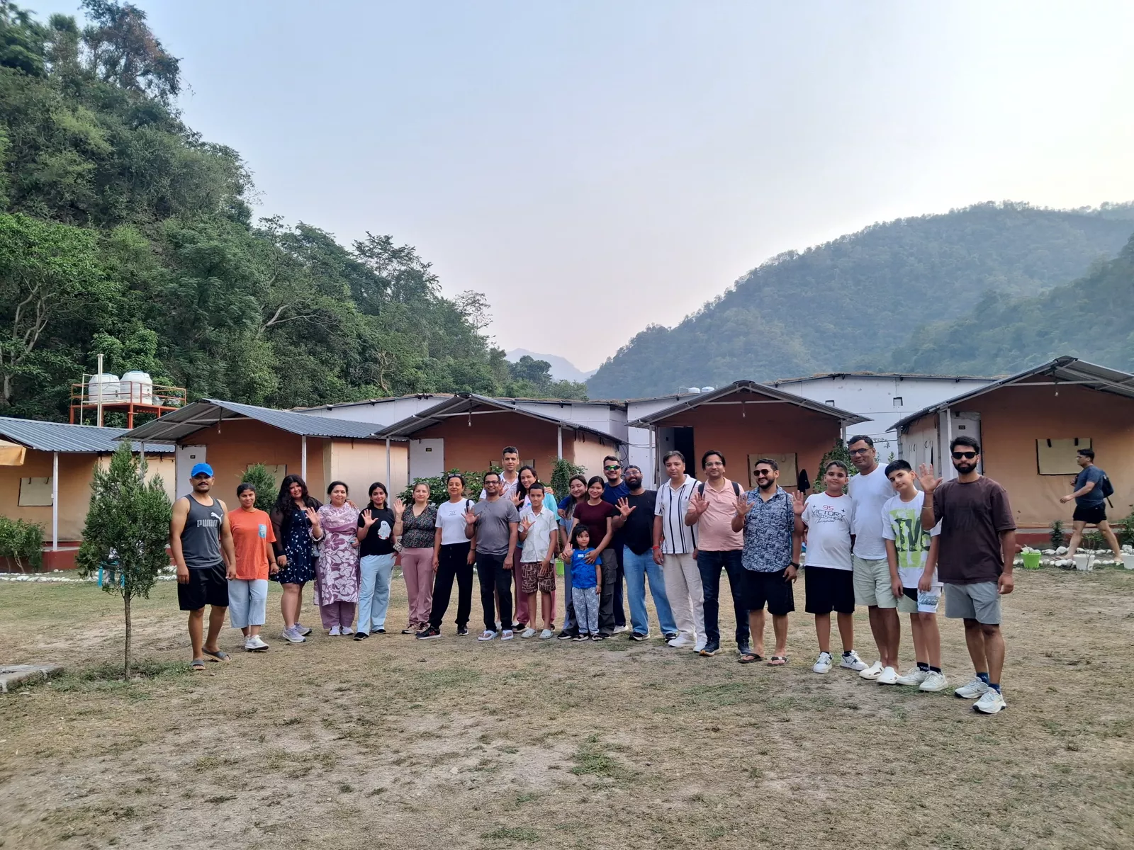 Group of guests at Himalayan Ganga Retreat riverside camp with Himalayan hills behind, Rishikesh