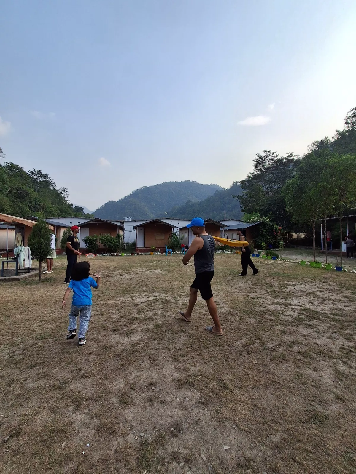 Guests playing badminton on the lawn at the riverside camp in Rishikesh