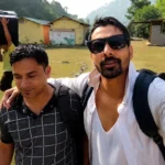 Two guests arriving at Himalayan Ganga Retreat, cottages and lawn behind, Rishikesh