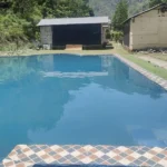 Swimming pool with mountain backdrop at Himalayan Ganga Retreat, Rishikesh