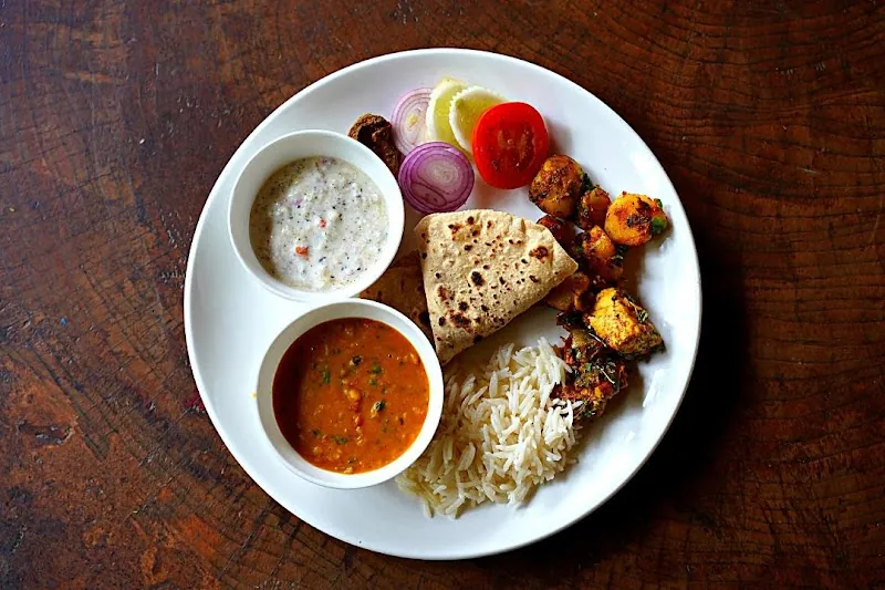 Traditional Pahadi thali served in copper utensils at the forest rest house