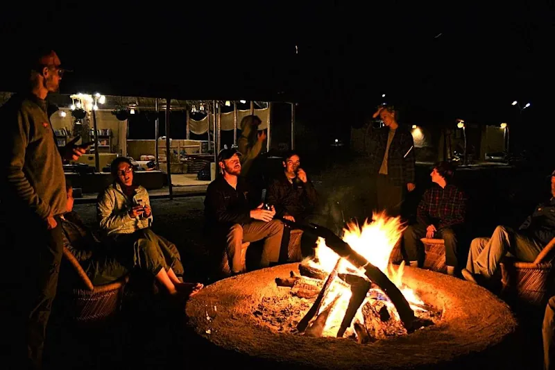 Guests gathered around the bonfire at night at the Rajaji forest retreat