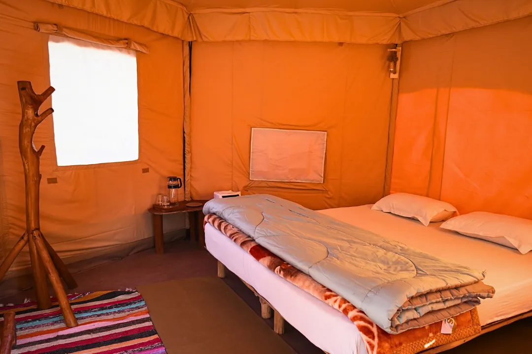 Tent cottage interior with comfortable bedding, forest stay near Rishikesh