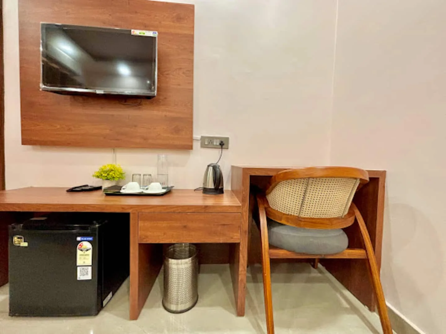 Work desk, mini fridge and kettle in a bedroom at Prembasant Homestay