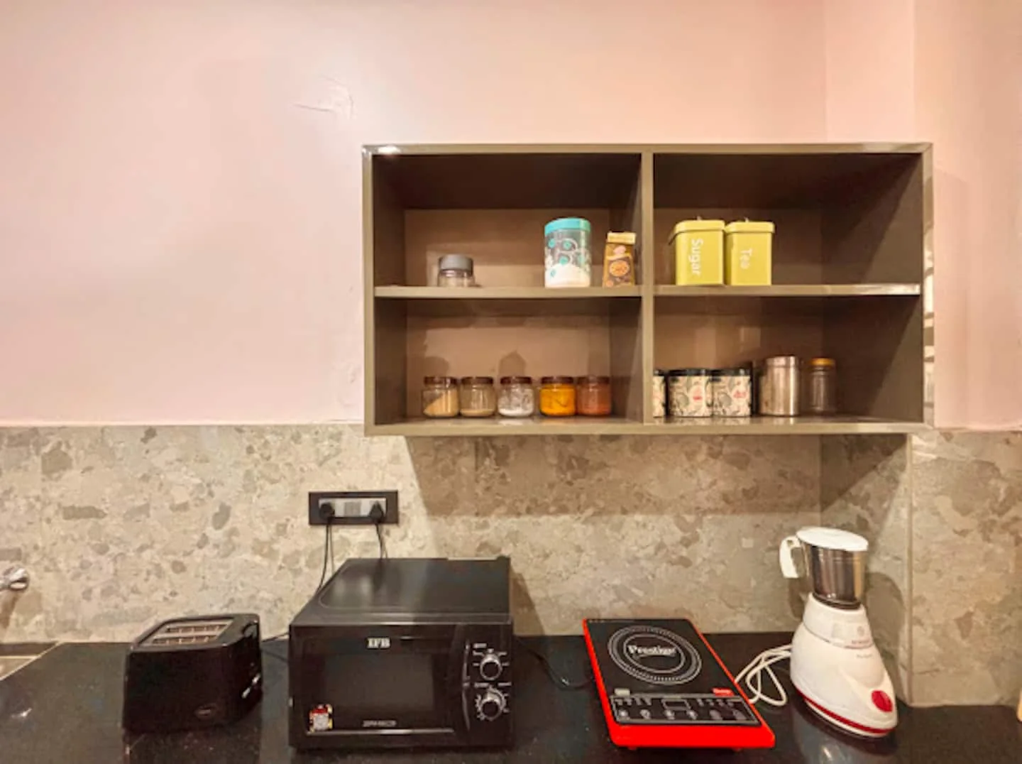 Kitchen shelves with induction cooktop and mixer at Prembasant Homestay