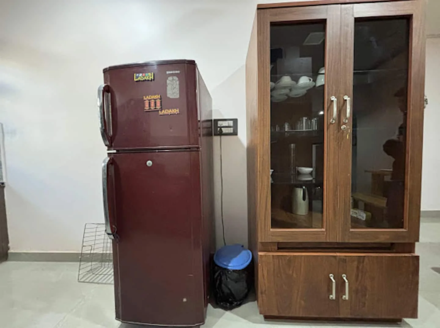 Refrigerator and crockery cabinet in the shared kitchen at Prembasant Homestay