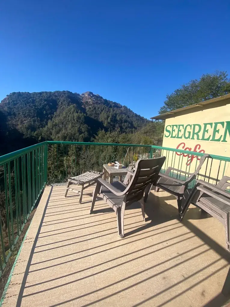 Rooftop sky-deck cafe at Seegreen Mussoorie with wooden chairs and mountain views