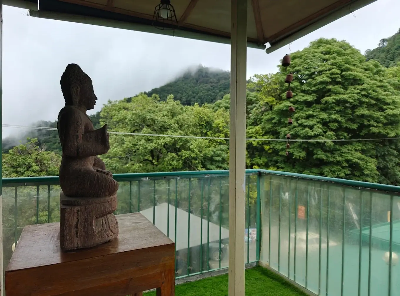 Rooftop deck with a sculpture and glass railing at Seegreen Cafe, Mussoorie