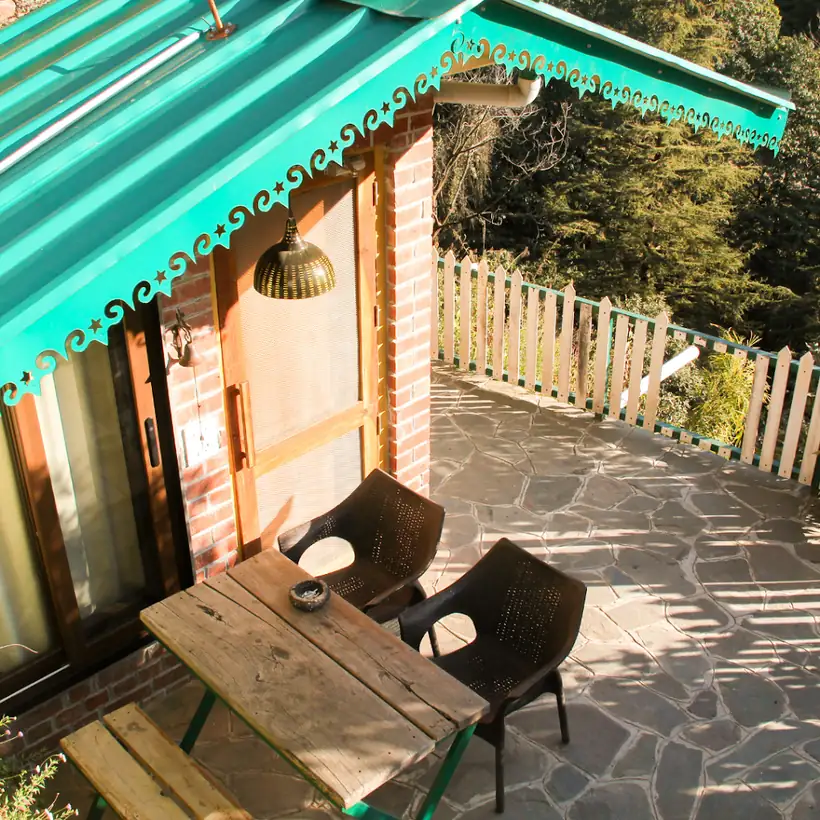 Cabin with a green awning and stone patio at Seegreen Mussoorie
