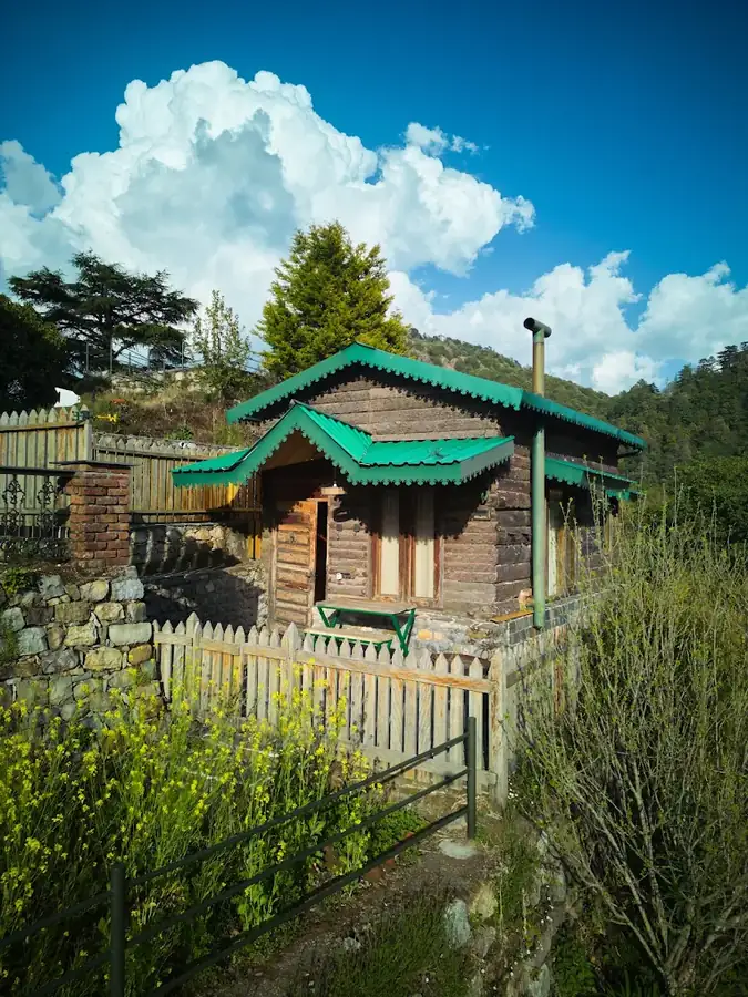 Green-roofed log hut in the garden at Seegreen Lodges, Mussoorie