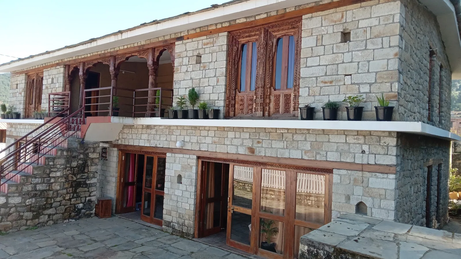The stone paved courtyard and steps up to the verandah at Basa Stay, Khirsu
