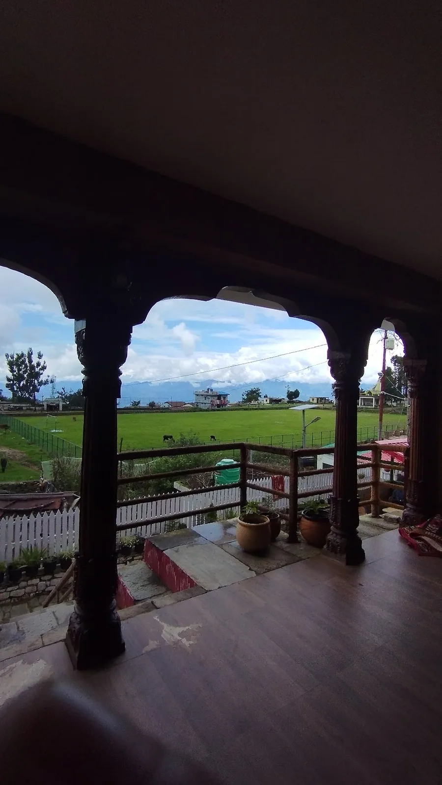 The covered wooden verandah running along the front of Basa Stay, Khirsu