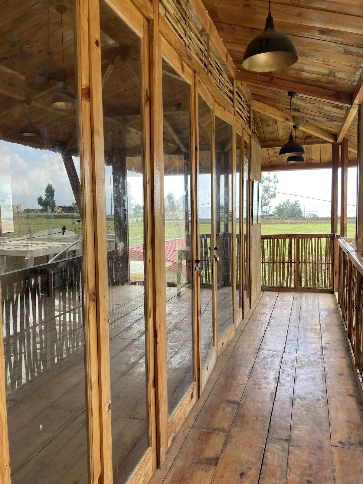 Timber framed corridor with glazed windows at Basa Stay, Khirsu