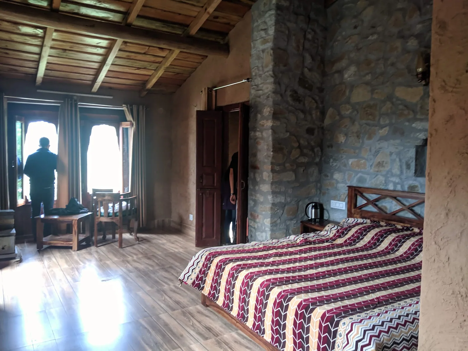 Room with a traditional bedspread and stone walls at Basa Stay, Khirsu