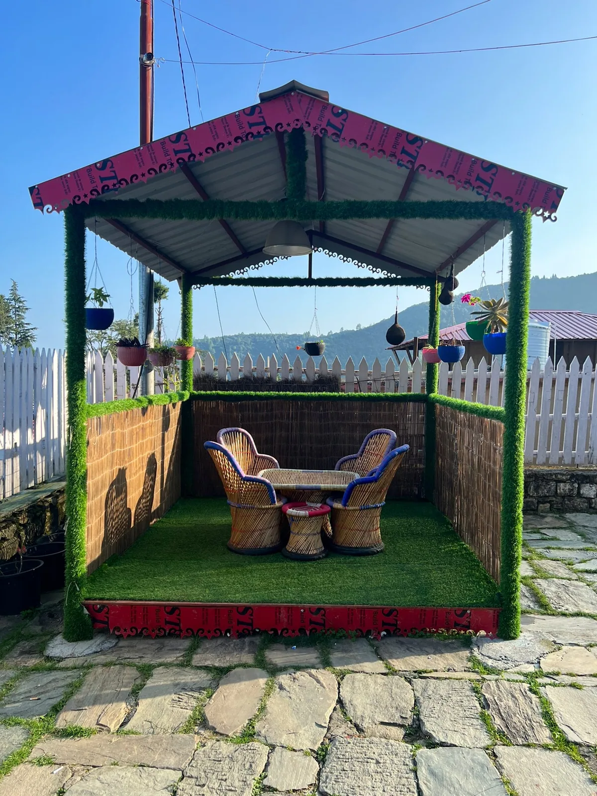 Green and red gazebo in the garden at Basa Stay, Khirsu