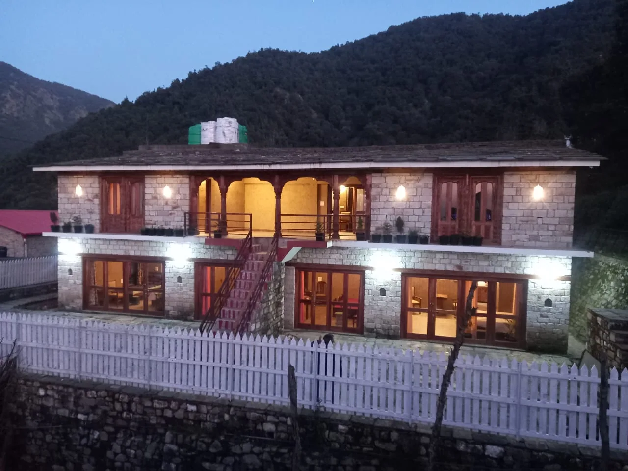 Lit verandah of Basa Stay after dark at Khirsu