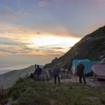 Tents on the ridge at Camp George Everest at first light, above a sea of cloud over the Doon Valley