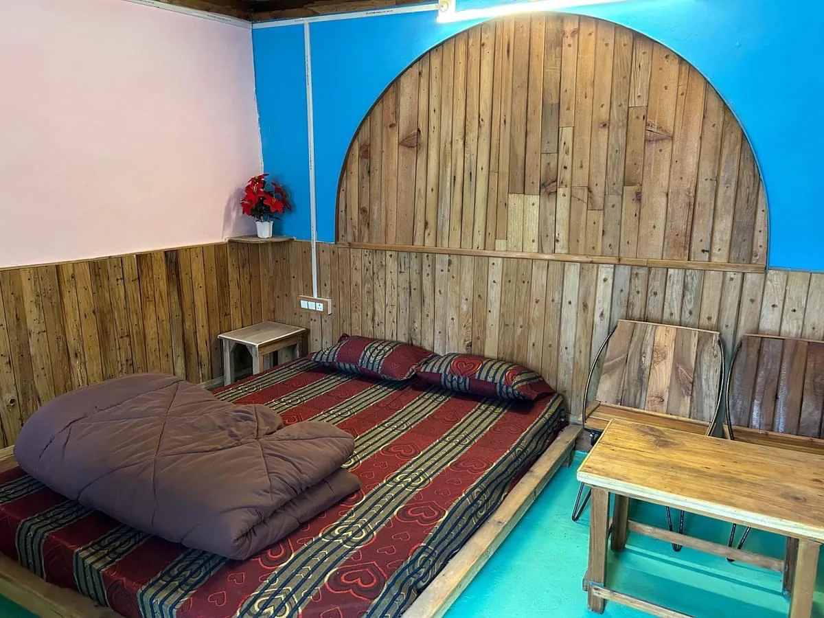 Wood panelled room with a low bed at Darshan Village Stay near Mussoorie
