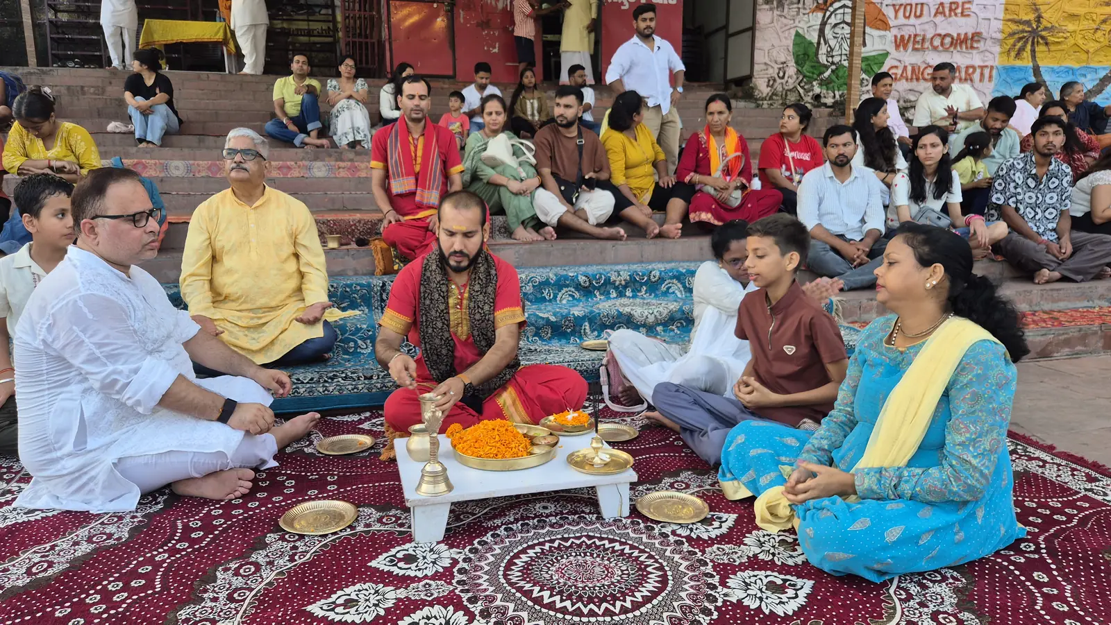 Priests performing the Ganga Aarti on riverside platforms at Rishikesh, hills and temple across the water