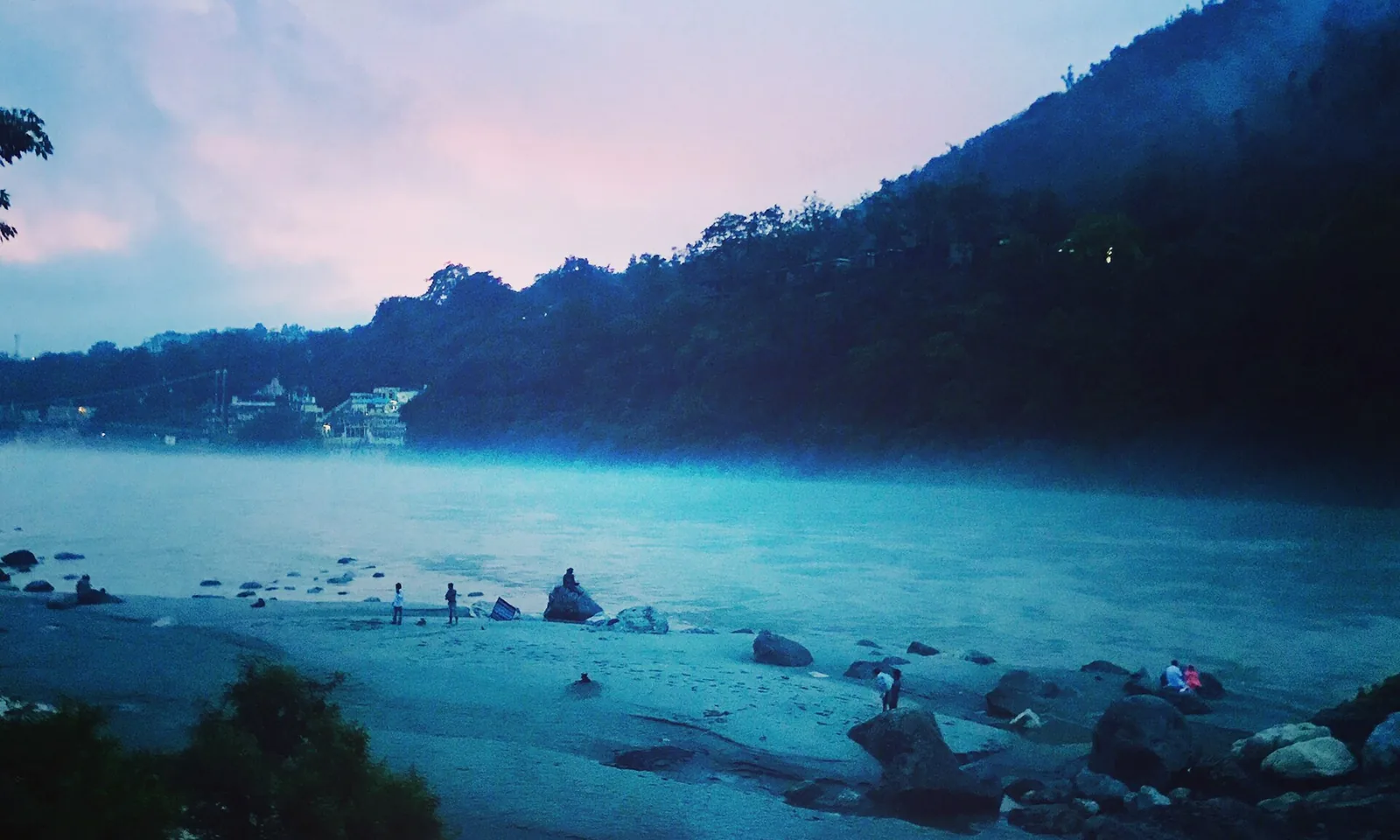 Quiet pebble and sand riverbank on the Ganga at dusk in the hills outside Rishikesh