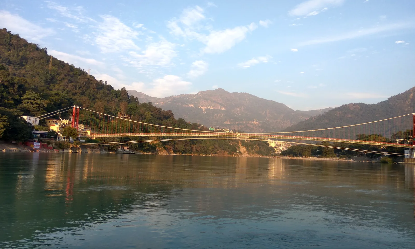 Suspension bridge across the Ganga at Rishikesh with the Tapovan bank and hills behind