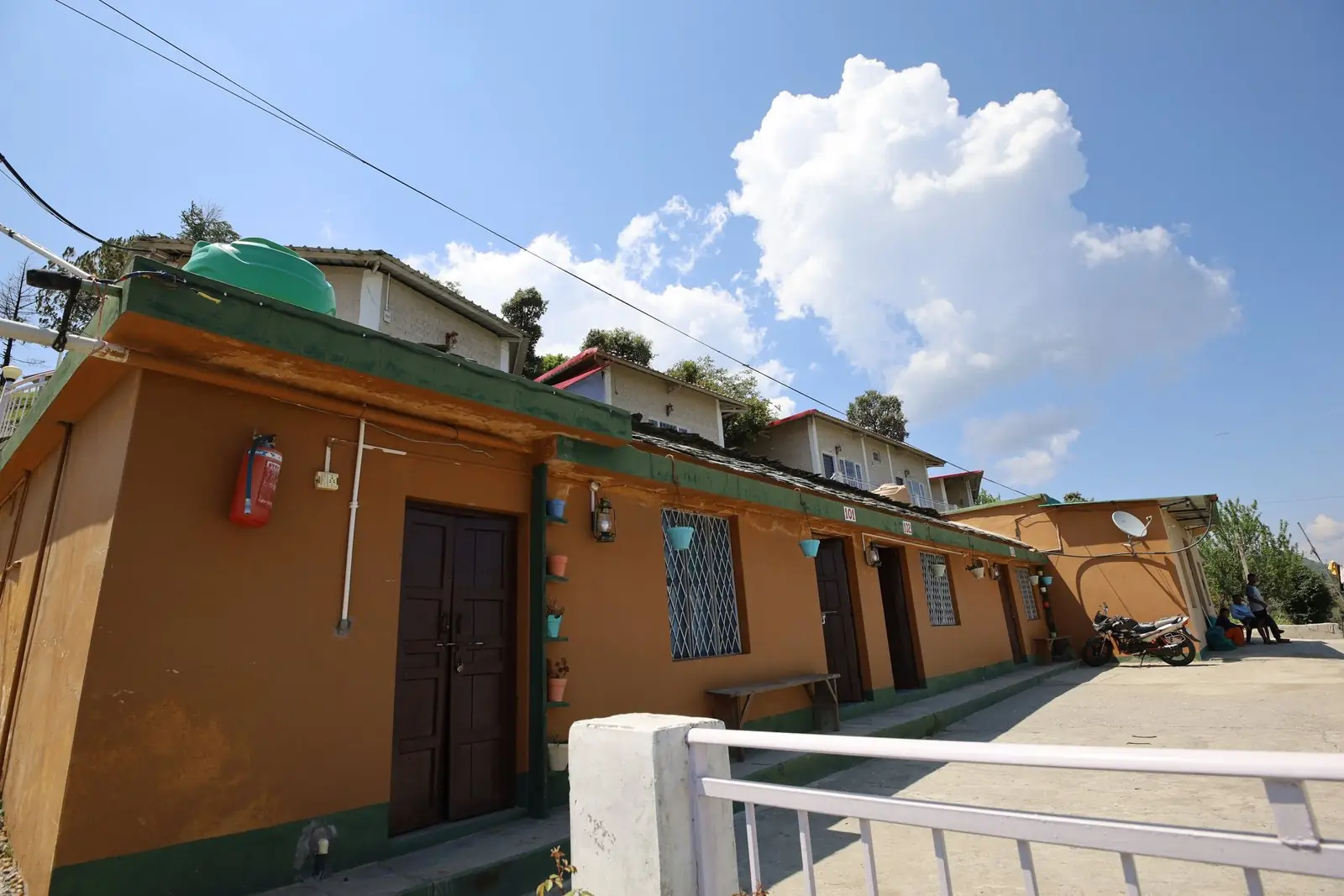 Cottage exteriors along the pathway at Pahadi Ghar