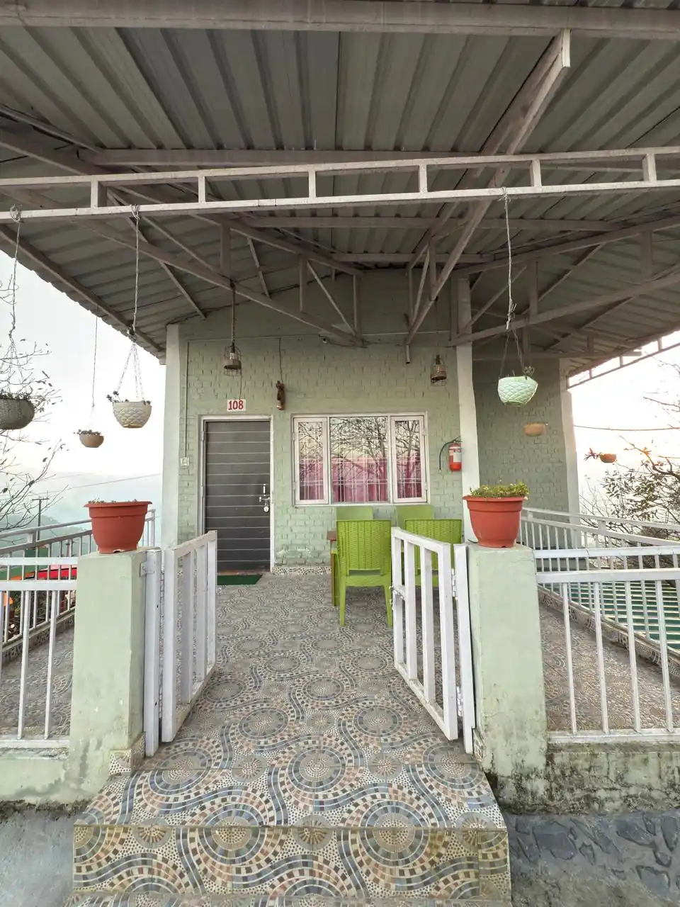 Covered verandah with seating overlooking the Kanatal valley