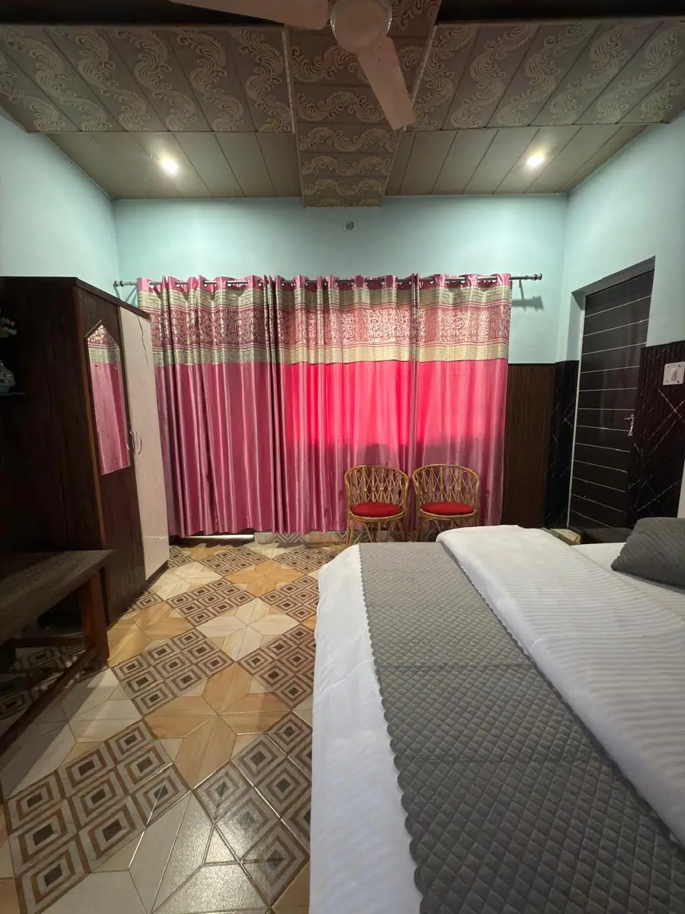 Spacious double room with tiled flooring and cane chairs