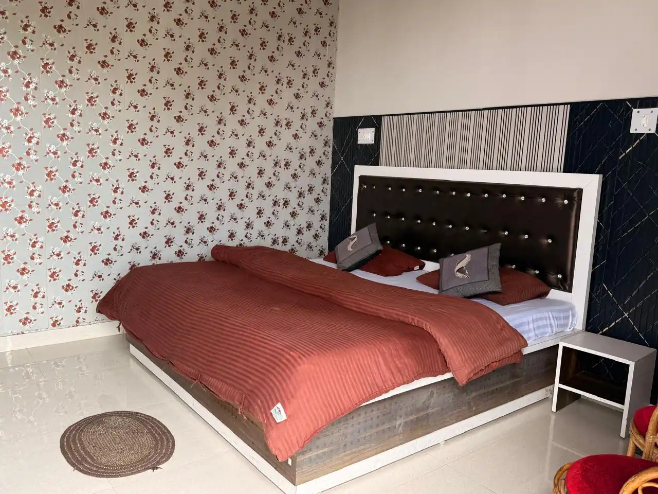 Double room with patterned wallpaper and warm bedding