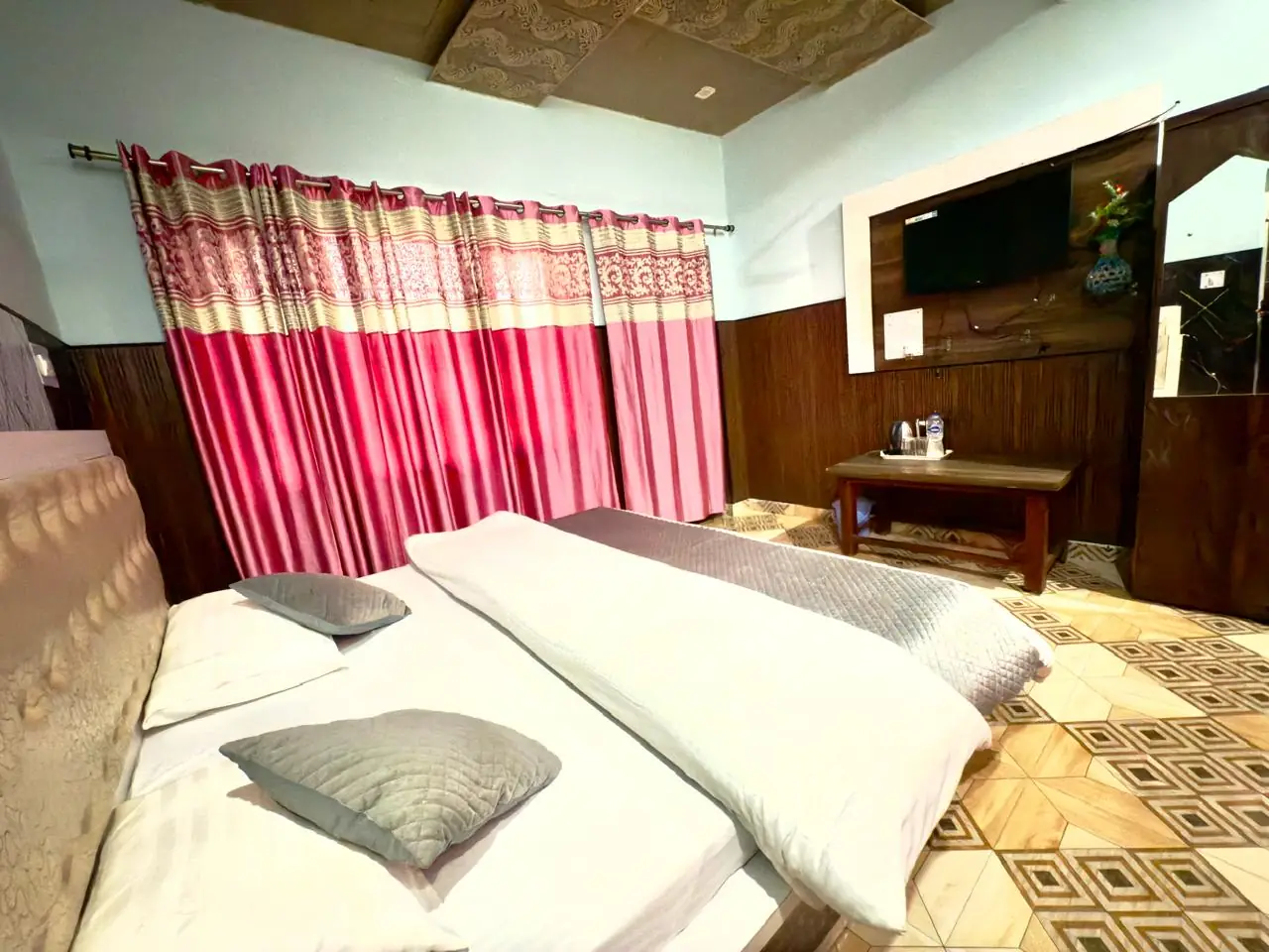 Twin beds made up in a family room at the Kanatal homestay