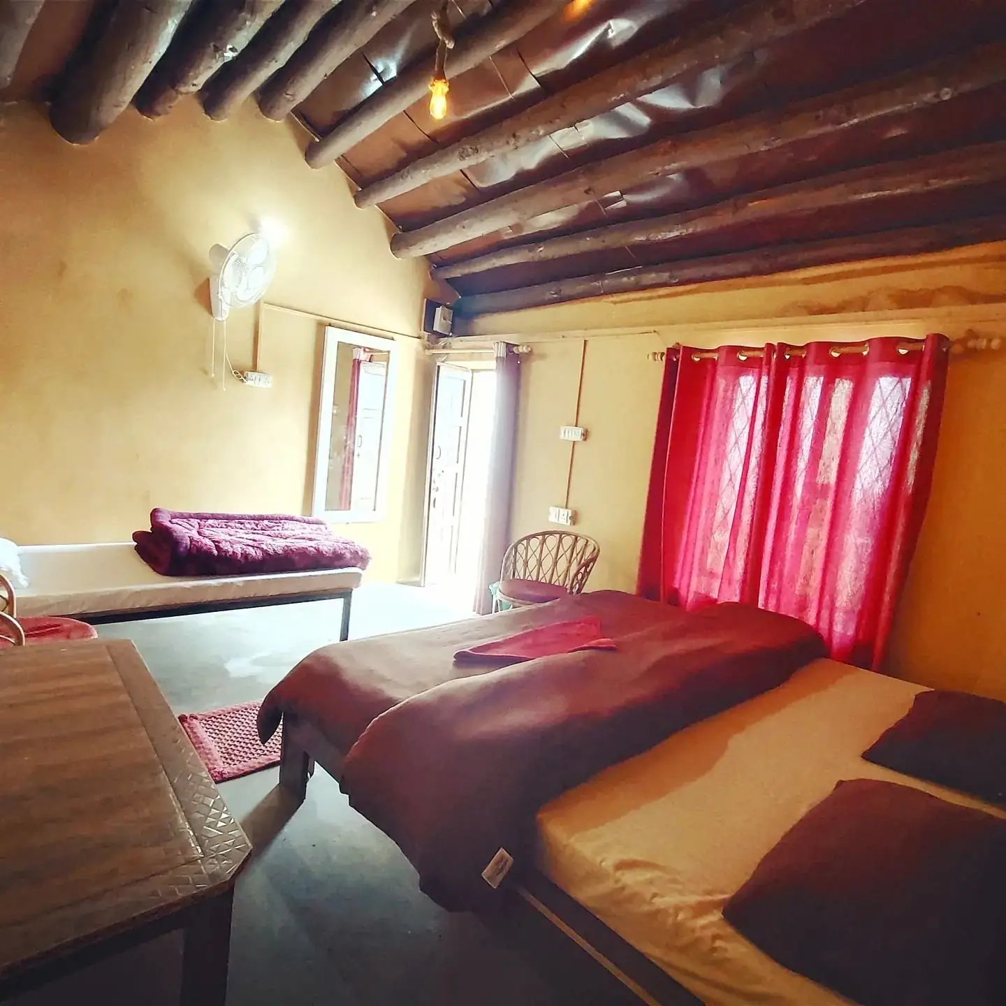 Room with exposed wooden beams and traditional pahadi walls
