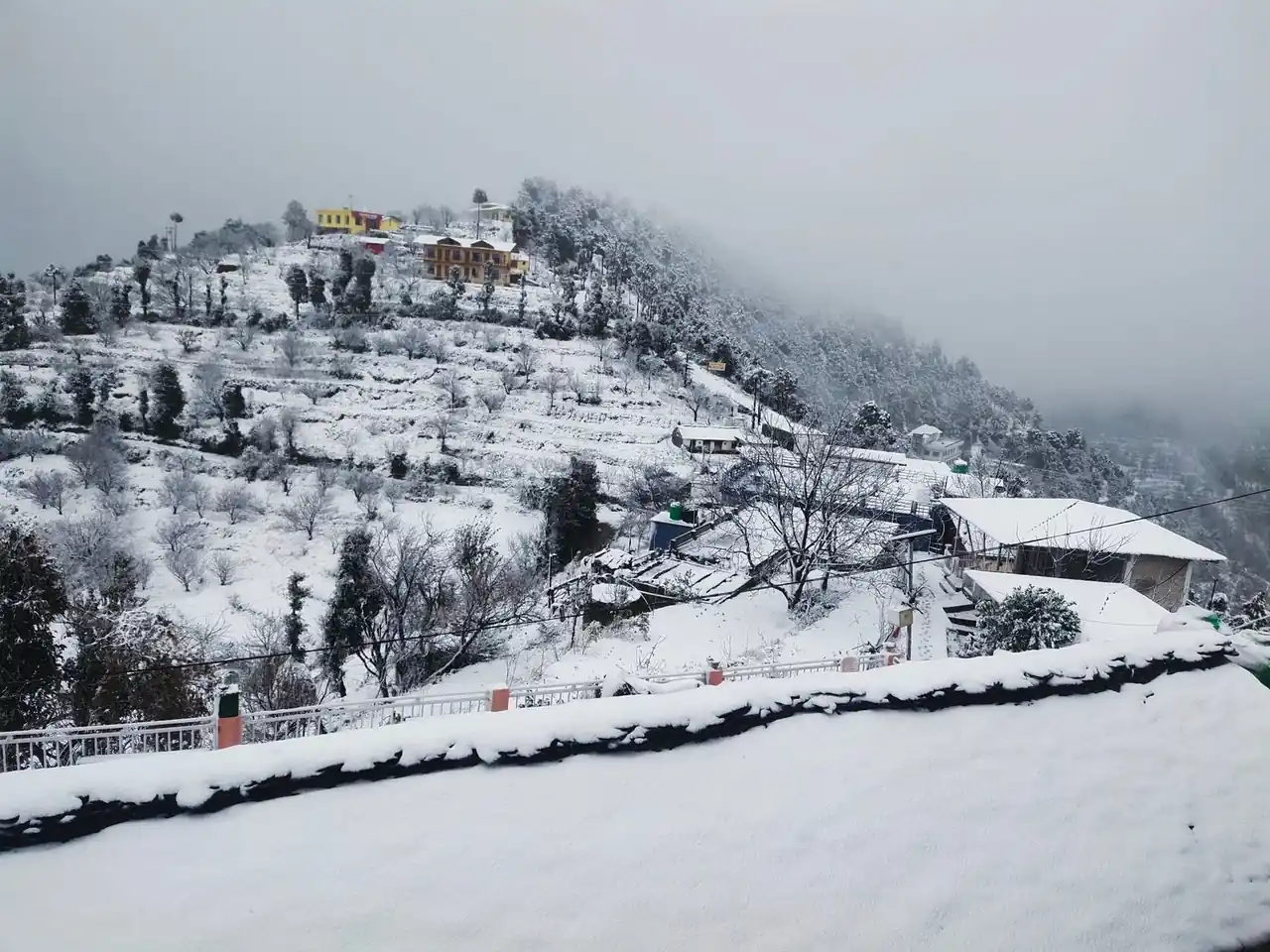 Snow-covered hillside and cottages in January