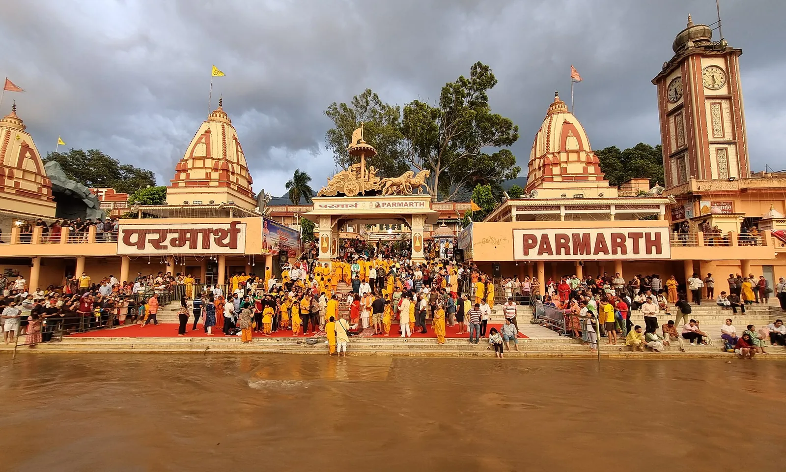 Crowds seated on the steps of the Parmarth Niketan ghat at Rishikesh before the evening Ganga Aarti