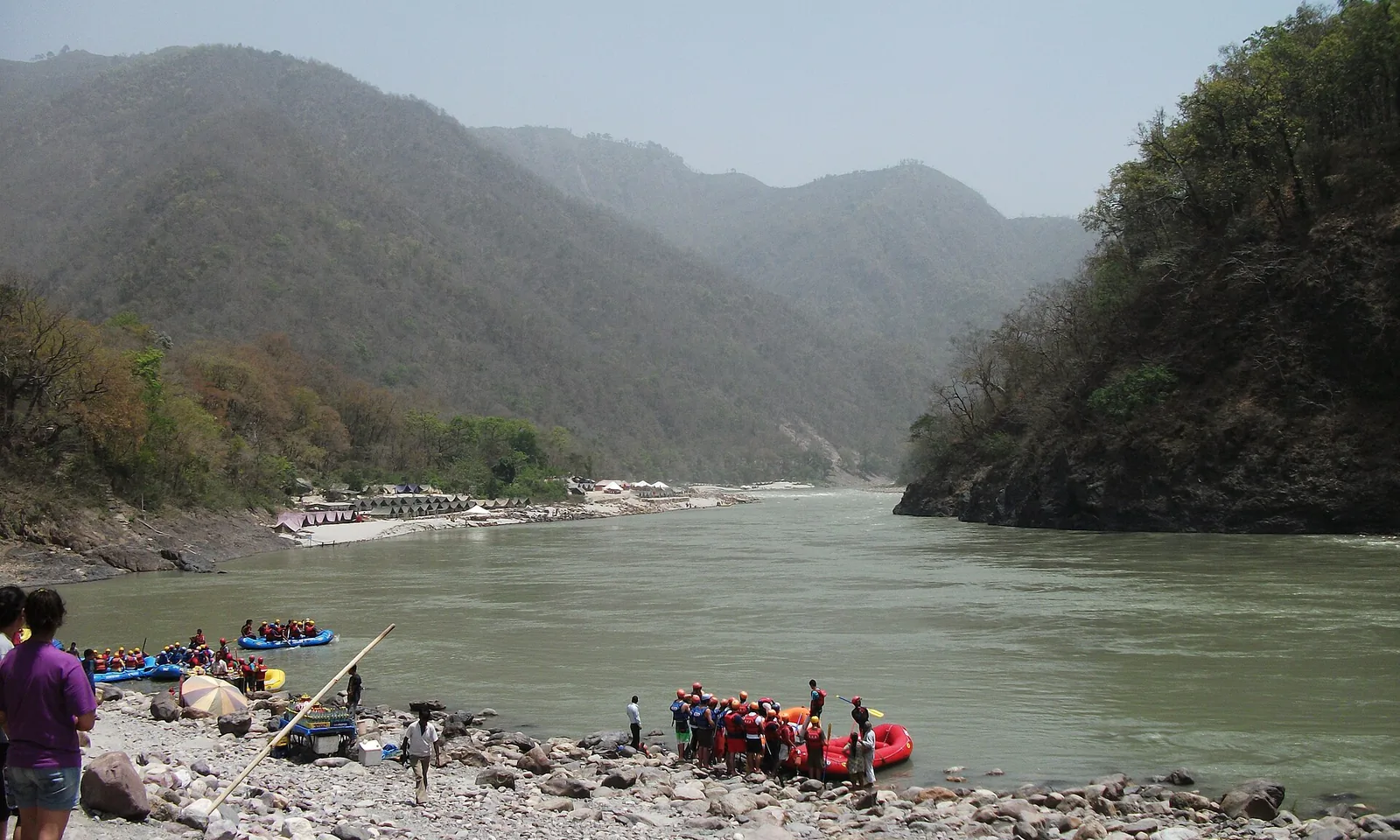 Rafts pulled up on the pebble beach at Shivpuri on the Ganga above Rishikesh, steep valley behind