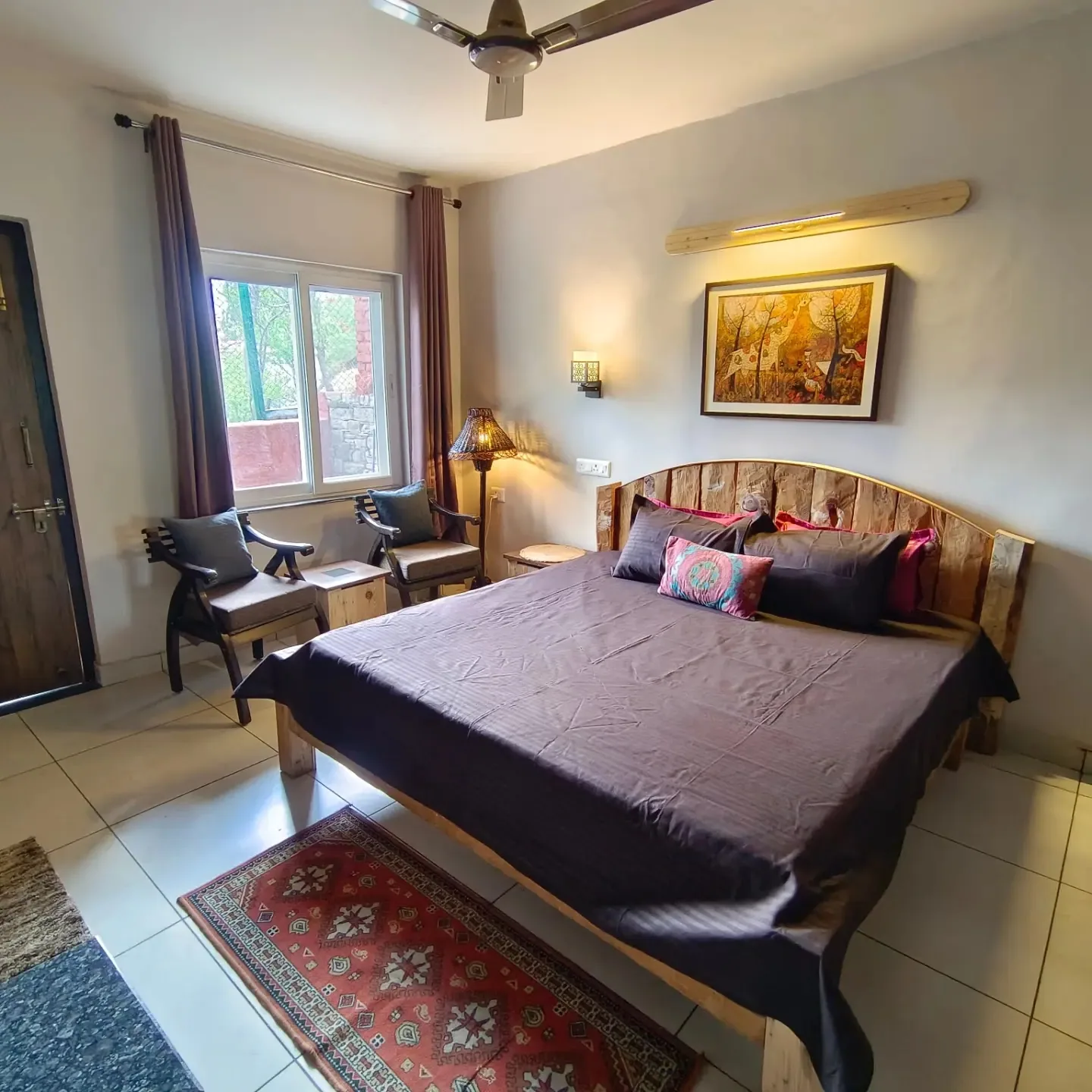 Bedroom with a wooden bed and rug at WindyRidge Plum Orchard Villa, Mukteshwar