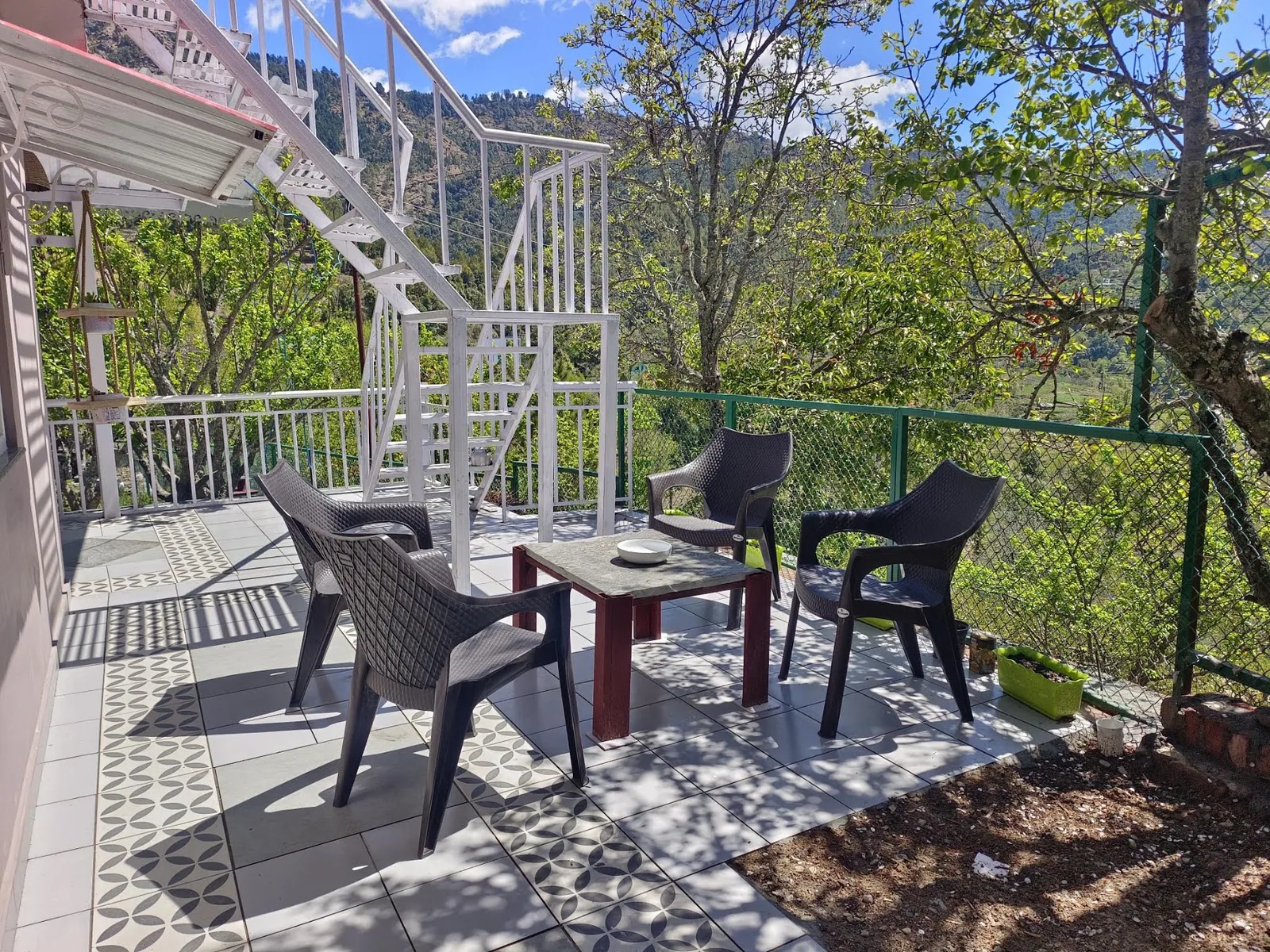 Table and chairs on the terrace at WindyRidge, looking over the Mukteshwar valley
