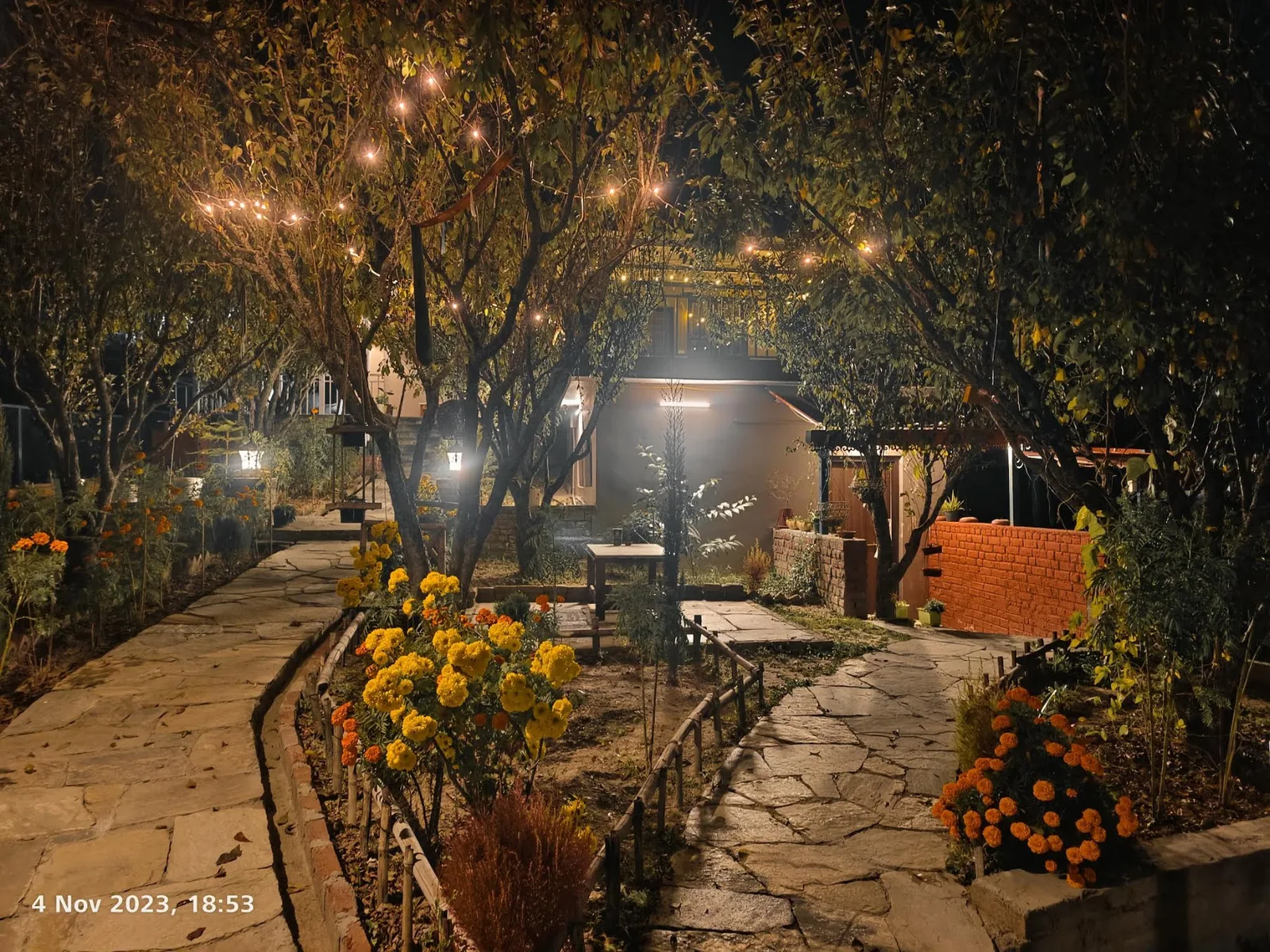 Fruit trees along the lit garden path at WindyRidge, Mukteshwar